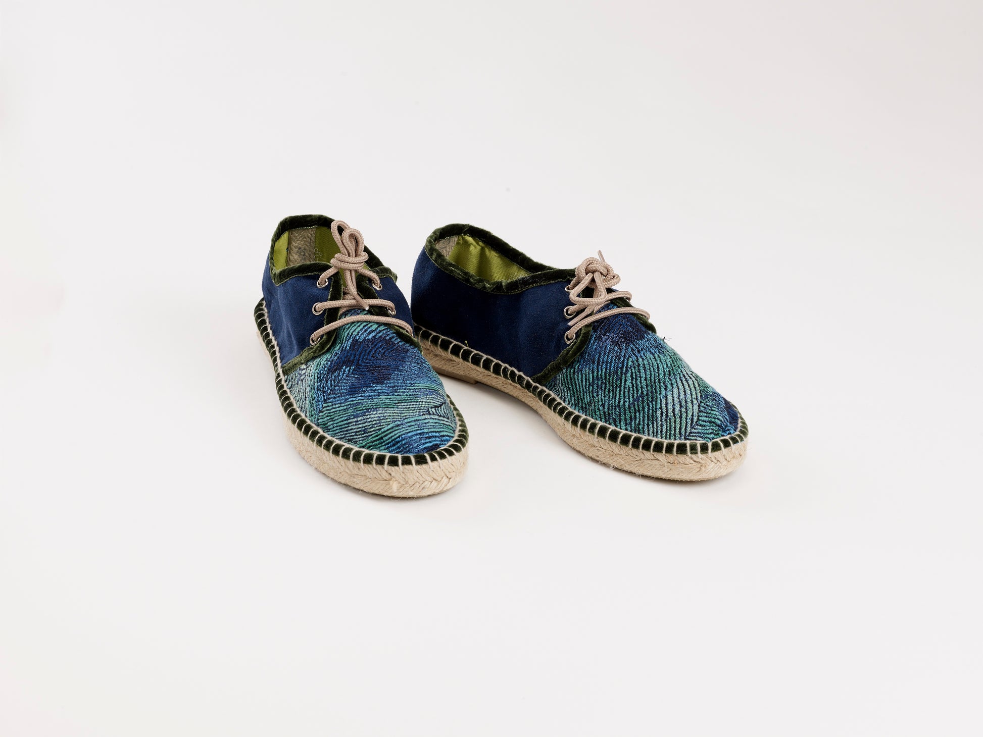 Alpargata para mujer plana, cierre con cordones, parte delantera en tejido estampado Pavo Real y parte trasera azul marino. Ribete en terciopelo verde Original y artesanal