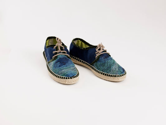 Alpargata para mujer plana, cierre con cordones, parte delantera en tejido estampado Pavo Real y parte trasera azul marino. Ribete en terciopelo verde Original y artesanal